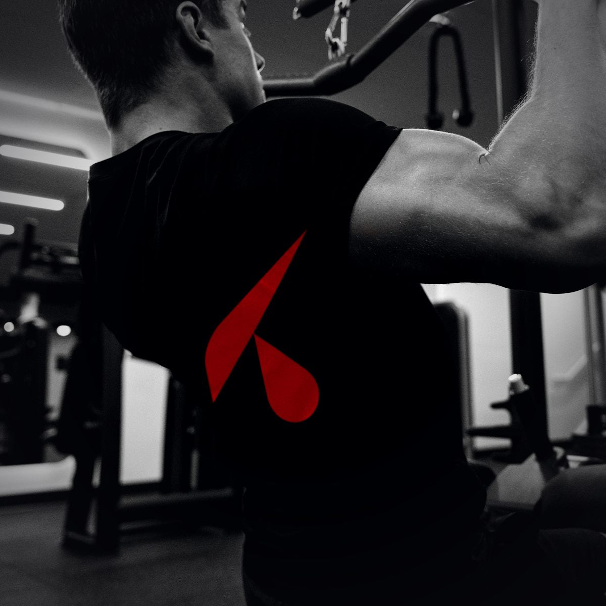 Allenamento in palestra con t-shirt nera e grande stampa del logo sulla schiena