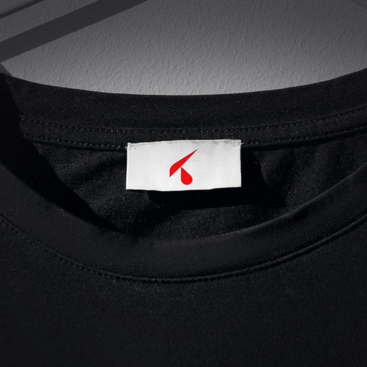 Etichetta tessile bianca con il logo K rosso cucita nel collo di una t-shirt nera