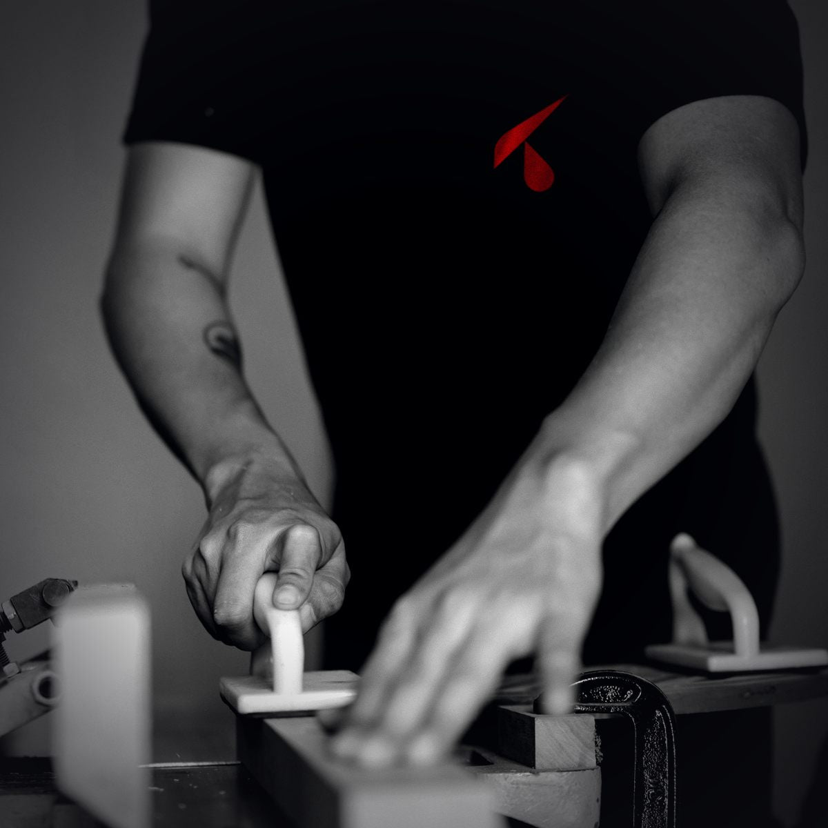 Artigiano al banco con t-shirt da lavoro personalizzata con il logo sul petto