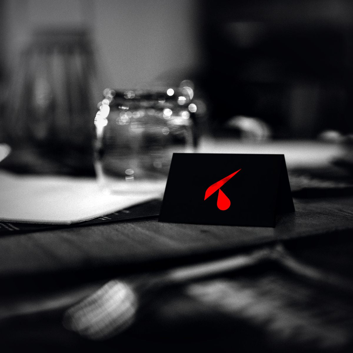 Segnaposto nero con logo su una tavola apparecchiata