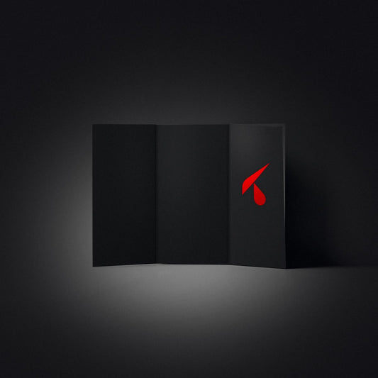 Pieghevole a tre ante in cartoncino nero aperto a ventaglio su un piano scuro, con il logo K rosso in copertina
