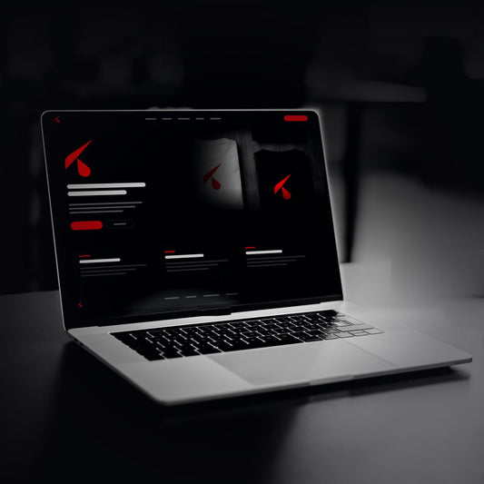 Sito web scuro con il logo K in testa aperto su un portatile, su una scrivania nera