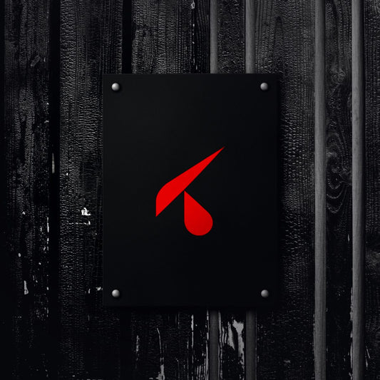 Targa in forex nera 30x40 con logo K rosso, fissata con distanziali cromati su una parete di legno scuro